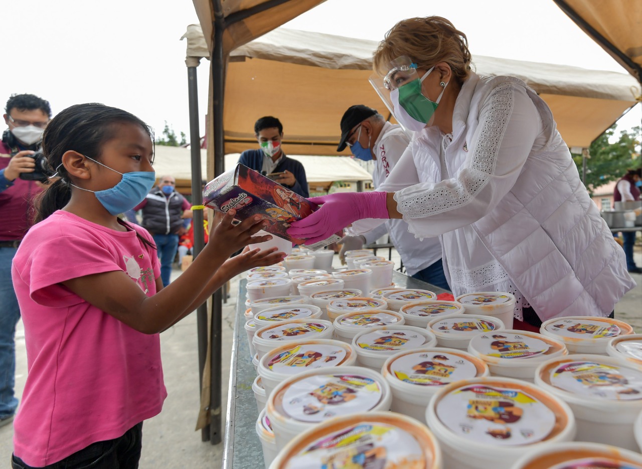 Ruth Olvera Nieto entrega comida caliente a una niña para que mejoren la dieta