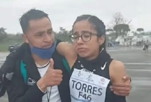 El entrenador Enrique Hernández sostiene a Daniela Torres en el maratón italiano