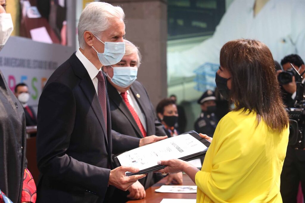 El gobernador del Estado de México, Alfredo del Mazo, entrega el reconocimiento a Maricruz Rivera