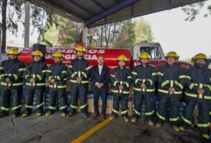 Alcalde Pedro Rodríguez entre bomberos con uniforme nuevo