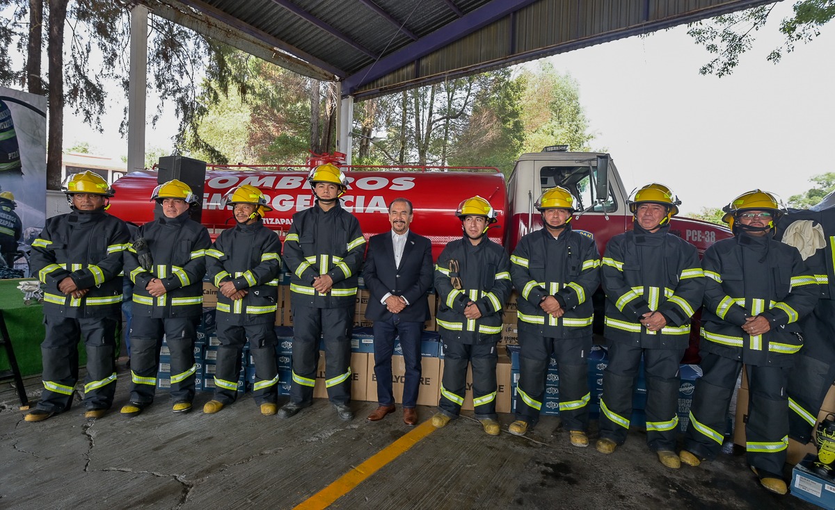 Alcalde Pedro Rodríguez entre bomberos con uniforme nuevo
